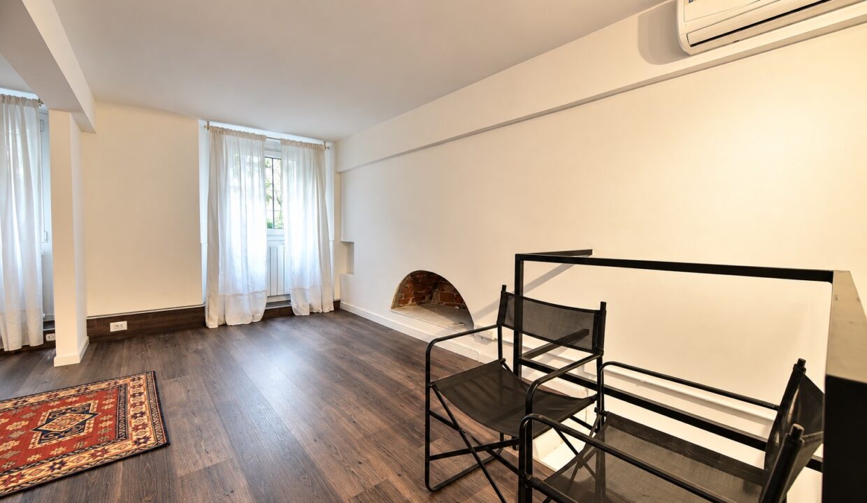 Interno moderno con sedie nere e camino in mattoni